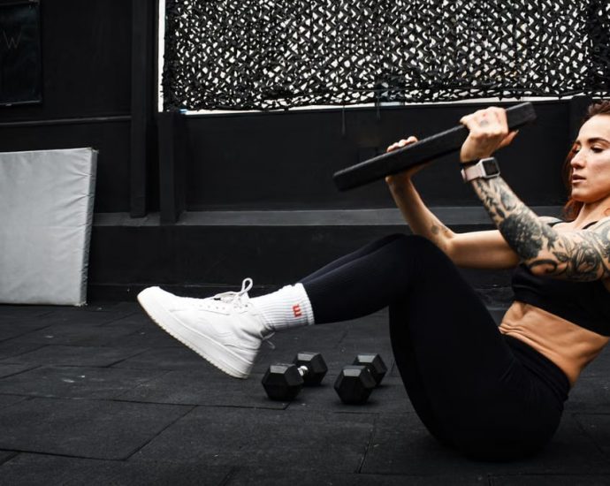 A determined woman performs a core workout in an indoor gym setting.
